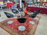 quatre chaises noires posées sur un tapis dans une pièce
