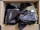 a cardboard box filled with clothes and a pair of shoes