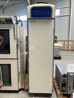 un homme debout devant une machine dans une usine