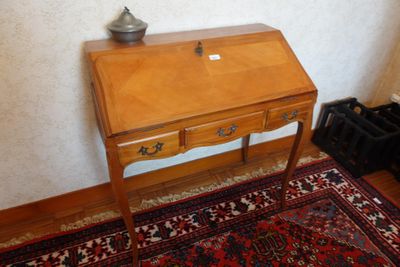 un petit bureau en bois sur lequel est posée une lampe