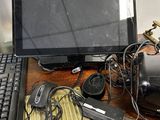 a desk with a computer, keyboard, mouse, and other electronics on it