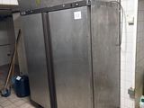 a stainless steel refrigerator in a kitchen with tile flooring