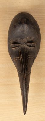 une image d'un masque en bois accroché au mur