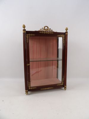 une vitrine ancienne en bois, dotée d'étagères en verre et de garnitures dorées