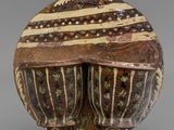 a close up of a decorative object on a stand on a gray surface