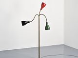 a red, green and black floor lamp in a corner of a room