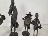 three bronze figurines of a man, woman, and child
