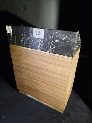 une boîte en bois avec un couvercle en marbre noir, posée sur une table