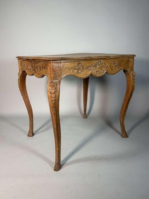 une image représentant une table en bois avec un plateau et des pieds sculptés