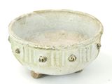 a white bowl that has holes in it on a white surface