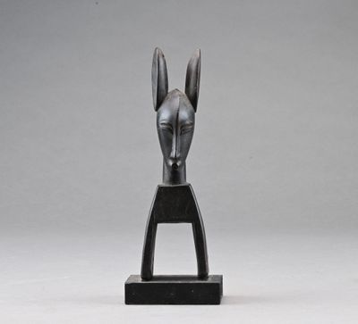 une sculpture noire représentant une tête de cheval, posée sur un socle noir