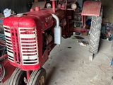 un tracteur rouge qui est garé dans un garage