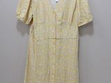 a yellow and white floral dress hanging on a hanger