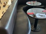 two tables and a couch in the corner of a restaurant