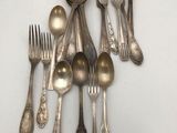 a lot of silver spoons and forks on the table