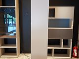 a tall white bookcase in the middle of a room