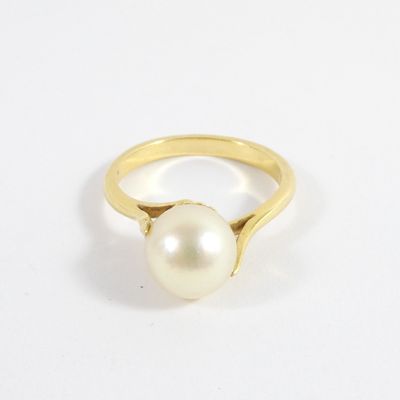 gros plan d'une bague en perle sur une surface blanche