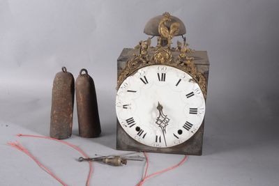 une horloge posée à côté d'une paire de cloches