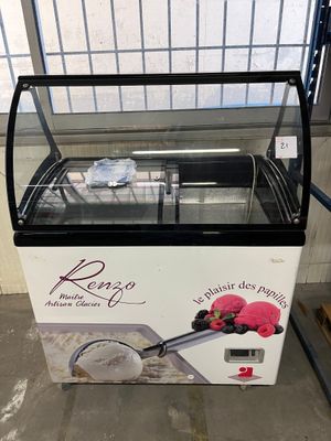 une machine à glaces posée devant une fenêtre dans un immeuble