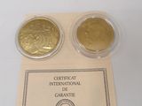 two gold coins sitting next to each other on a table