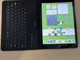un ordinateur portable et une tablette posés sur un bureau, avec un clavier
