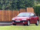 a red car that is parked in front of a fence