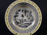 assiette jaune et noire sur laquelle est représenté un château