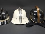 three helmets are lined up on a black surface