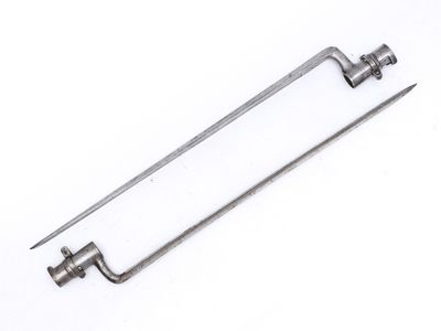 une paire d'outils métalliques posés sur une surface blanche