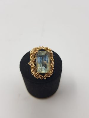a gold ring with an aquamarinee stone in the center