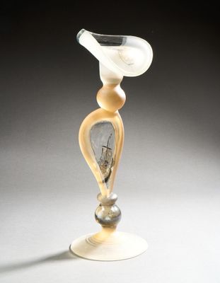 a glass vase that has a white and yellow design on it