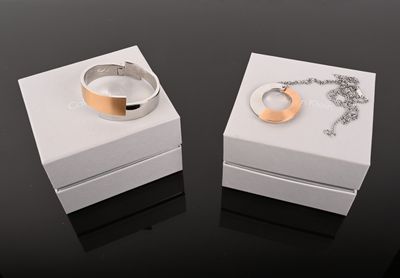 CALVIN KLEIN. Parure comprenant un jonc ouvrant et pendentif…