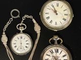 Trois types différents de montres de poche sont exposés sur un fond noir