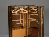 an open suitcase with clothes hangers and a suit case