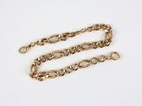 a close up of a gold chain on a white surface