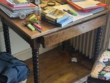 une petite table sur laquelle sont posés de nombreux livres, dans un coin de la pièce