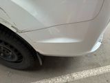 a close up of a white car with a denting on it