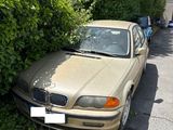 cars parked on the side of the road near bushes and trees
