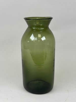 un vase en verre vert posé sur une table