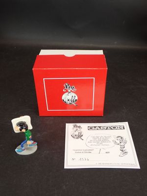 une petite figurine représentant un chien, dans une boîte rouge
