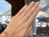 a woman ' s hand with a diamond ring on it