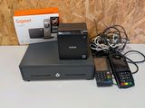 une boîte contenant des télécommandes et une imprimante posée sur une table