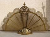 a gold fan sitting on the floor next to a wall