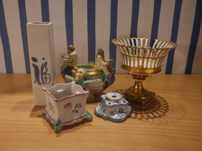 une table sur laquelle se trouvent un vase, un bougeoir et d'autres objets