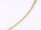 une image représentant un collier en or orné d'un serpent sur fond blanc