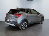 the rear end of a silver car parked in a showroom