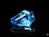 a close up of a blue diamond sitting on top of a black surface