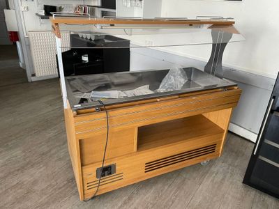 un comptoir en bois avec un plateau en métal et une vitrine en verre
