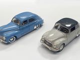 two toy cars sitting next to each other on a white surface