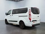 the rear of a white van parked in a large room